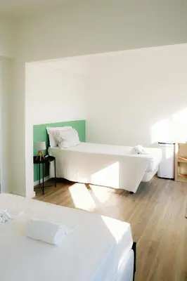 a white bedroom with two beds and a tub at Dona Maria Guest House in Faro