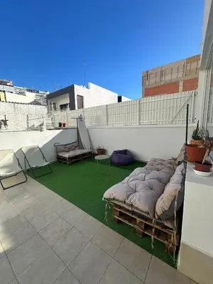 a balcony with a bed and chairs on a roof at Dona Maria Guest House in Faro