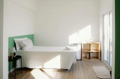 a white bed in a room with a table at Dona Maria Guest House in Faro