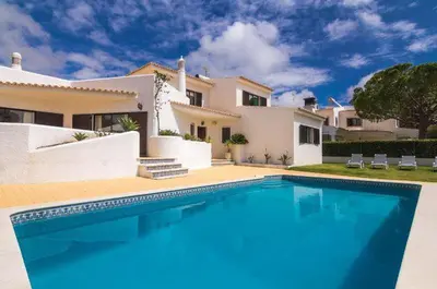 a large swimming pool in front of a house at Vivenda Duas Sentinelas 42 in Quarteira