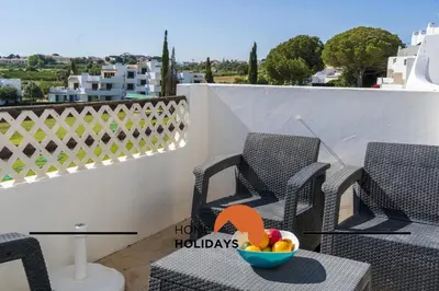 a balcony with chairs and a bowl of fruit on a table at #315 Apartamento Turistico by Home Holidays in Atalaia
