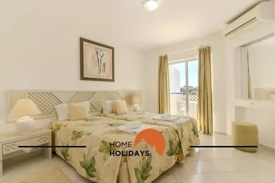 a bedroom with a bed with a home holidays sign on it at #315 Apartamento Turistico by Home Holidays in Atalaia