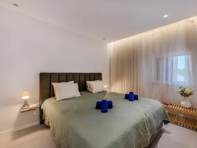a bedroom with a large bed with blue pillows on it at Apartment Sol Salgado by Interhome in Albufeira