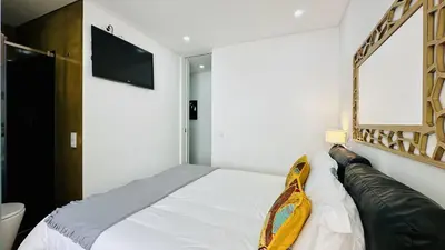 a bedroom with a bed and a tv on the wall at Pescadores by Check-in Portugal in Albufeira