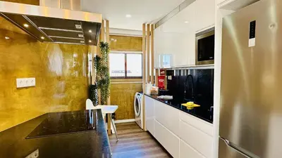 a kitchen with a black counter and a refrigerator at Pescadores by Check-in Portugal in Albufeira