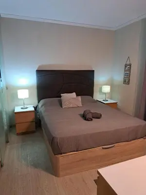a bedroom with a large bed with two lamps at SMILE Apartment Albufeira in Albufeira
