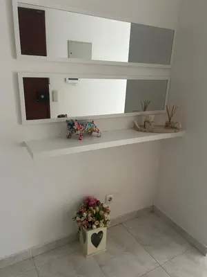 a white room with a mirror and a vase with flowers at Penha House II in Faro