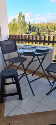 a glass table and a chair on a balcony at Porto Marina Vilamoura LG Studio in Quarteira
