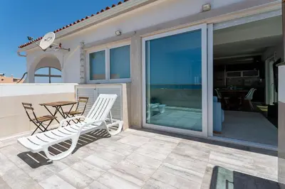 a pair of chairs and a table on a patio at Blife Charlya private apartment at Faro beach in Faro