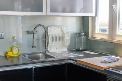 a kitchen sink with a dish drying rack next to it at Blife Charlya private apartment at Faro beach in Faro