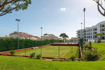 a tennis court in the middle of a park at Luz do Mar in Olhos de Água