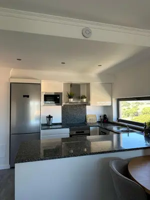 a kitchen with a counter top and a refrigerator at Luz do Mar in Olhos de Água