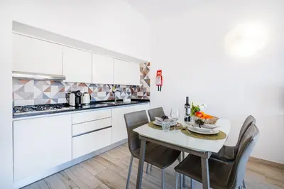 a kitchen with white cabinets and a table with chairs at Apartment Atlas in Albufeira