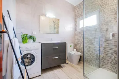 a bathroom with a washing machine and a toilet at Apartment Atlas in Albufeira