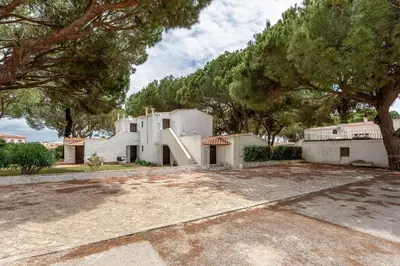 a large white house with trees in front of it at Charming Yellow Studio in Albufeira in Olhos de Água