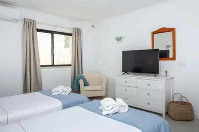 a bedroom with two beds with blue and white sheets at Downtown Apartment - By D`alma Portuguesa in Albufeira
