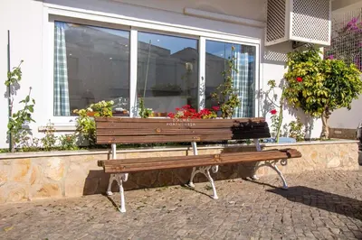 a wooden bench sitting in front of a window at Downtown Apartment - By D`alma Portuguesa in Albufeira