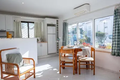 a kitchen and dining room with a table and chairs at Downtown Apartment - By D`alma Portuguesa in Albufeira