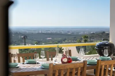 a wooden table with wine glasses and a pot on top at Casa Federica by Algarve Holidays in Santa Bárbara de Nexe