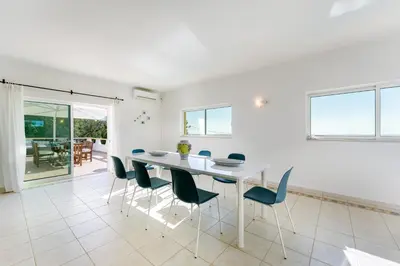 a white dining room with a white table and chairs at Casa Federica by Algarve Holidays in Santa Bárbara de Nexe