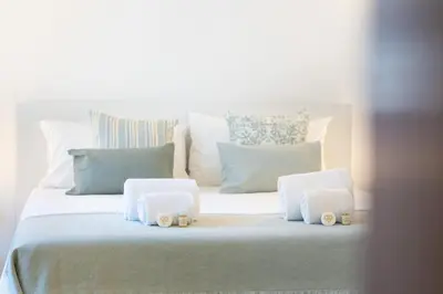 a white bed with white pillows and towels on it at Casa Federica by Algarve Holidays in Santa Bárbara de Nexe