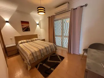 a bedroom with a bed and a large window at Villa Duarte in Albufeira