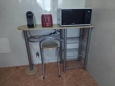 a table with a microwave and a chair on it at Villa Duarte in Albufeira