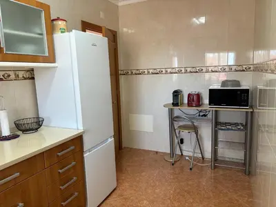 a kitchen with a refrigerator and a table with a microwave at Villa Duarte in Albufeira