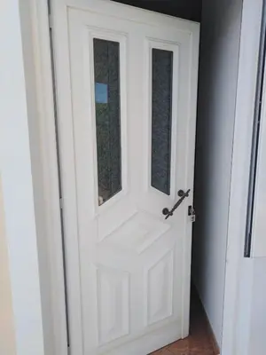 a white door with a window in a hallway at Villa Duarte in Albufeira