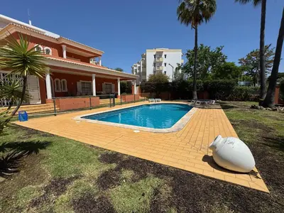 a swimming pool in front of a house at Palm Villa in Albufeira