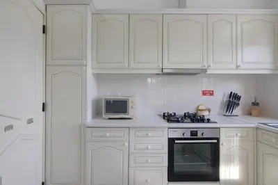 a white kitchen with white cabinets and a microwave at Sail Golf Vilamoura V3 in Quarteira