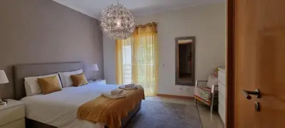 a bedroom with a large bed and a chandelier at Encosta Da Orada Vista Mar in Albufeira