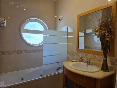 a bathroom with a tub and a sink and a mirror at Encosta Da Orada Vista Mar in Albufeira