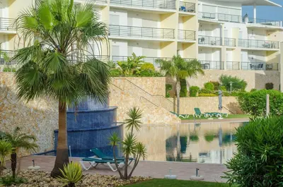 a swimming pool in front of some apartment buildings at Encosta Da Orada Vista Mar in Albufeira