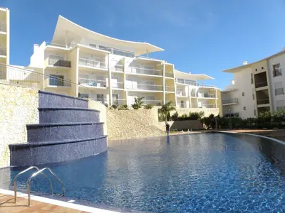 a balcony with a table and chairs and buildings at Encosta Da Orada Vista Mar in Albufeira