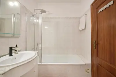 a bathroom with a tub and a sink and a shower at 2 Bedroom by Quarteira Beach in Quarteira