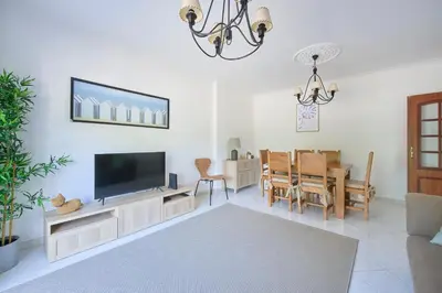 a living room with a television and a dining room at 2 Bedroom by Quarteira Beach in Quarteira