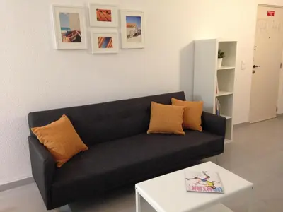 a black couch in a living room with a table at Casa Vila Magna in Albufeira