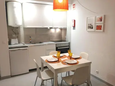 a kitchen with a table and chairs and a kitchen with white cabinets at Casa Vila Magna in Albufeira