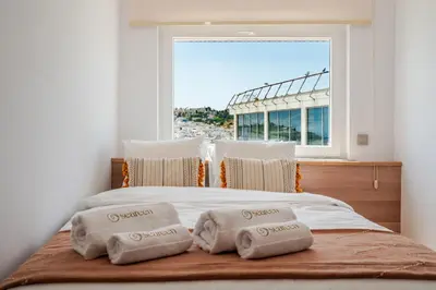 a bed with three towels on it with a window at Sandora Pearl By Seareen, Penthouse with sea view in Albufeira