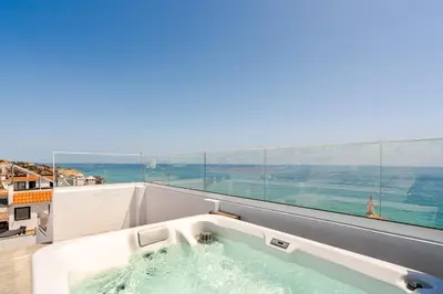 a bath tub with water in a room with a window at Sandora Pearl By Seareen, Penthouse with sea view in Albufeira