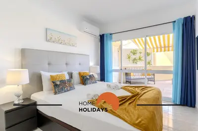 a bedroom with a bed and a room with a window at #283 Palmeira Gale by Home Holidays in Galé
