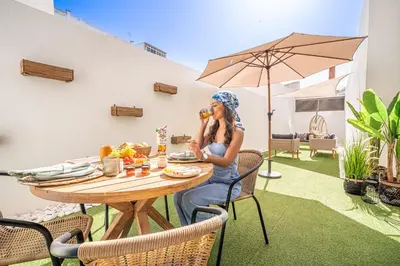 a woman sitting at a table eating food at Downtown Luxury Studio - Faro in Faro