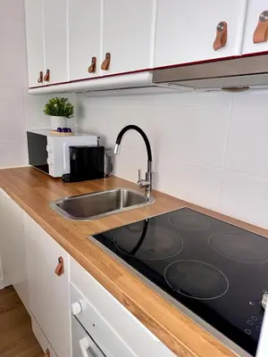 a kitchen counter with a sink and a microwave at Vilamoura Living 106 in Quarteira