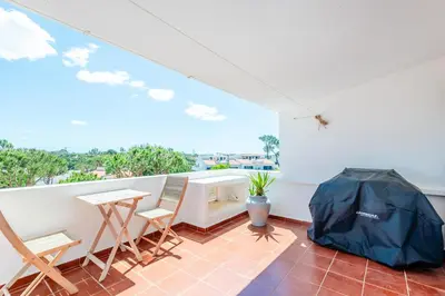 a room with a balcony with a table and chairs at Vale do Lobo Apartment D in Vale do Lobo