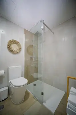 a bathroom with a toilet and a glass shower at Apartamento JADA in Albufeira