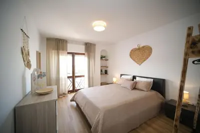 a bedroom with a bed and a heart on the wall at Apartamento JADA in Albufeira