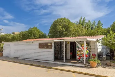 a small white building with a store at Albufeira Club 109 in Albufeira