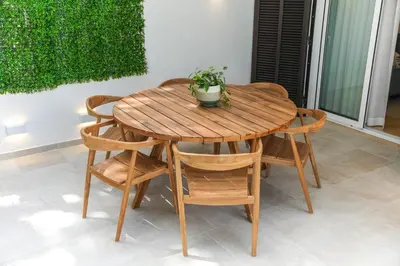 a wooden table and chairs with a potted plant on it at Luxury Garden House Apartment - Golf & Tennis Court & Pools in Albufeira