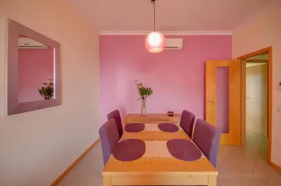 a dining room with a table and purple walls at Apartament Encosta Da Orada in Albufeira
